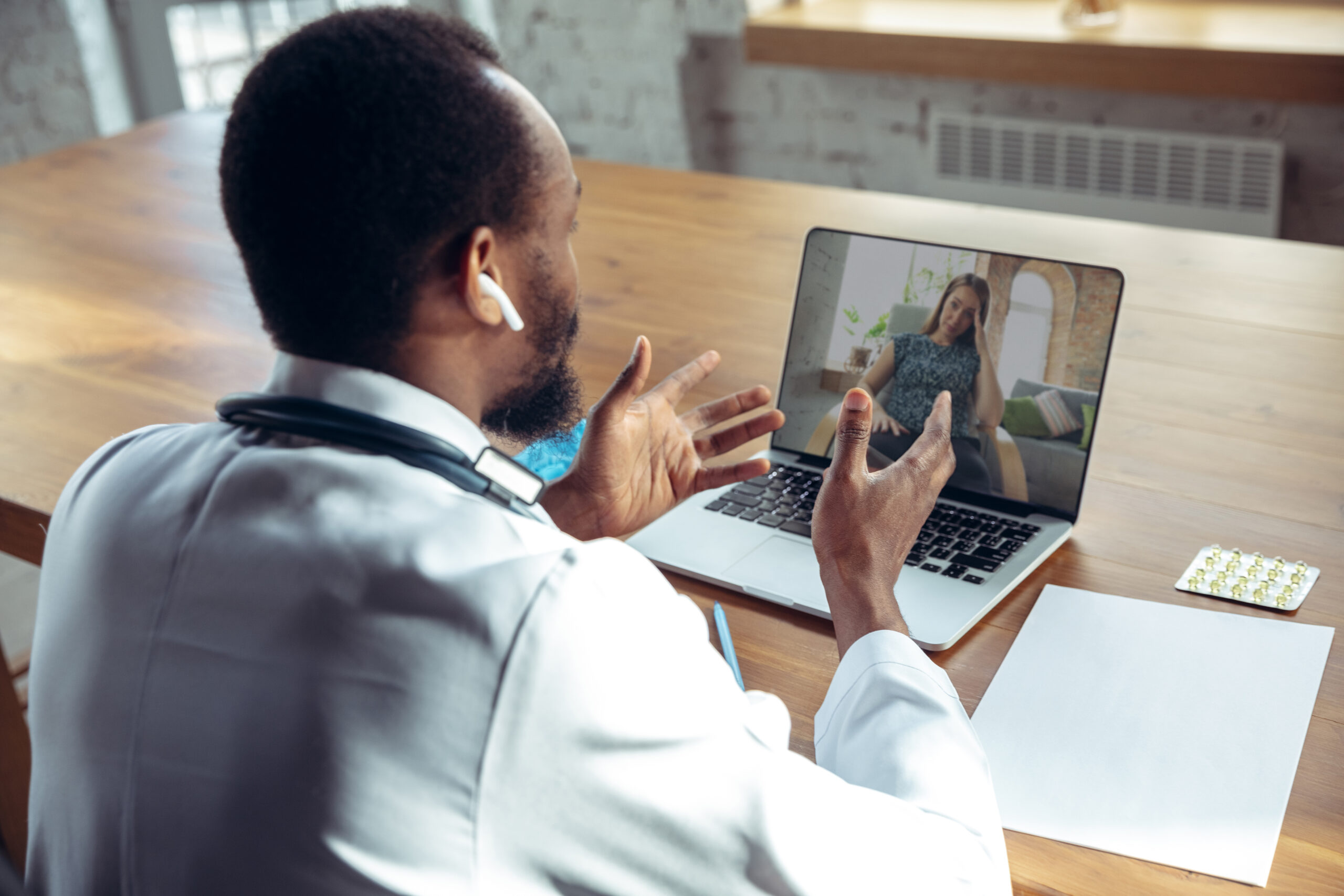 Médico consultando paciente por videochamada